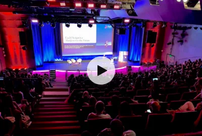 Image of a large conference from the far back with Thorsten Jonas on stage